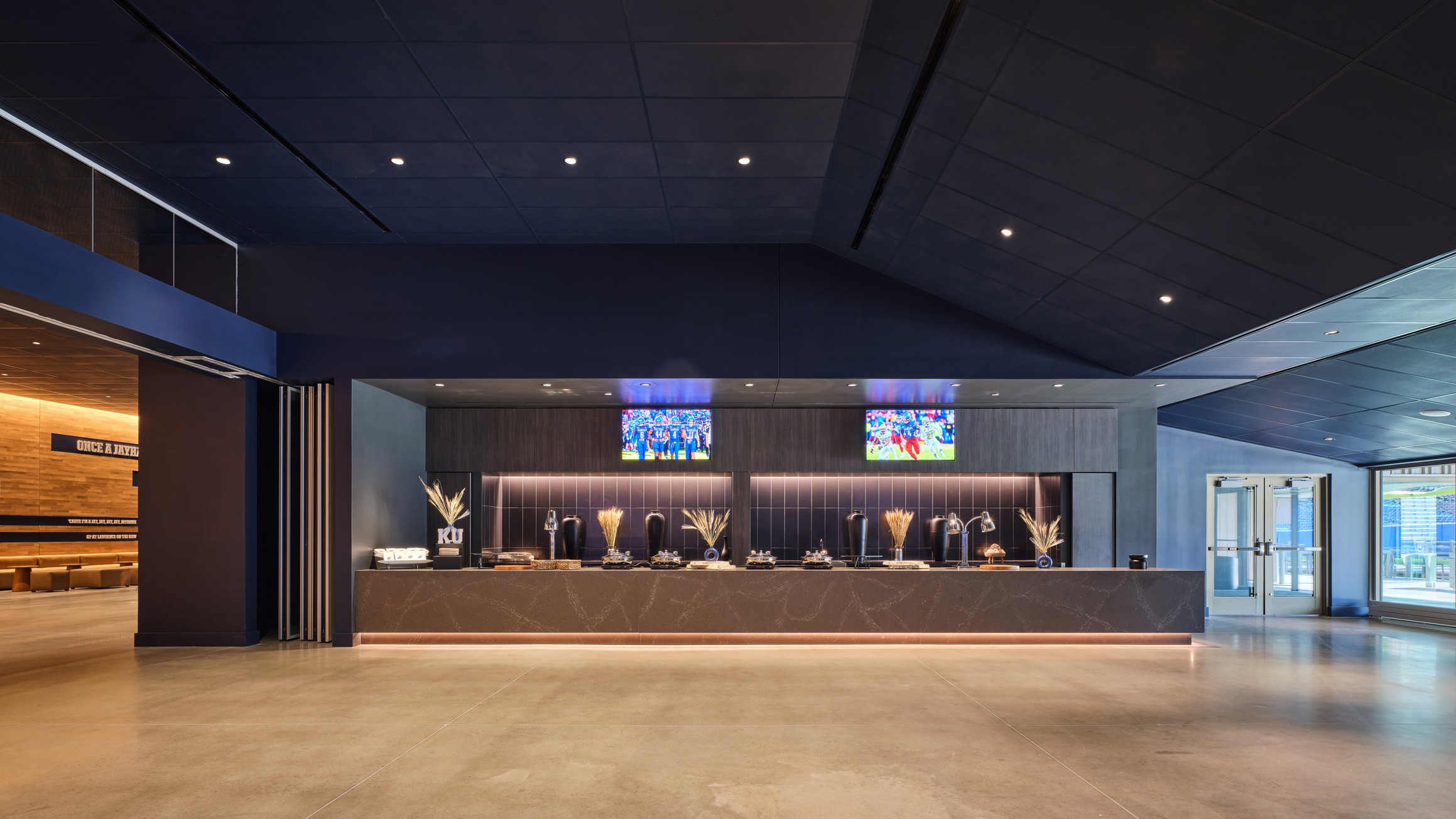 A long black buffet table sits between the welcome hall and the field. 