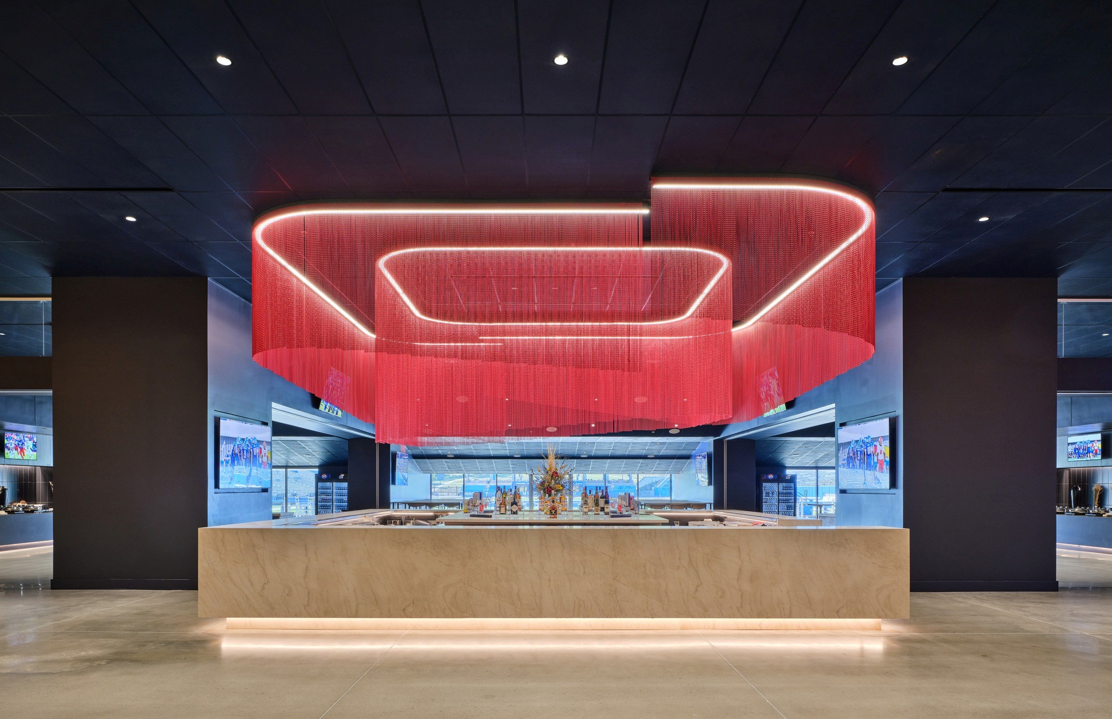 Illuminated red chain mail hangs over a 360-degree bar. 