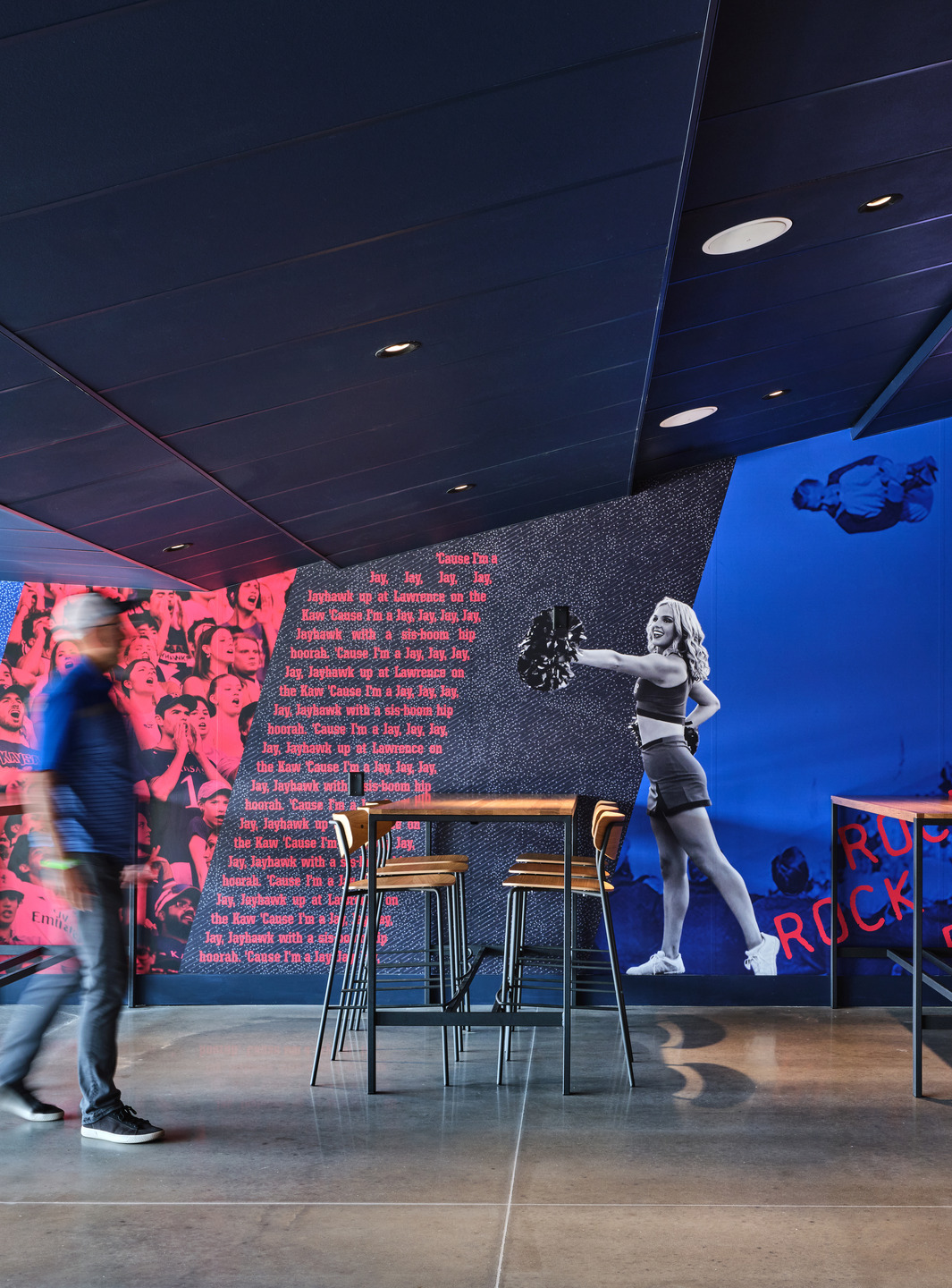 Red and blue wall graphics match the KU brand colors.