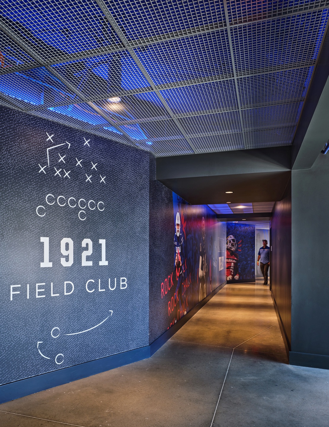 Custom graphics in KU's red and blue brand colors adorn the hall between the Field Club and the stadium.
