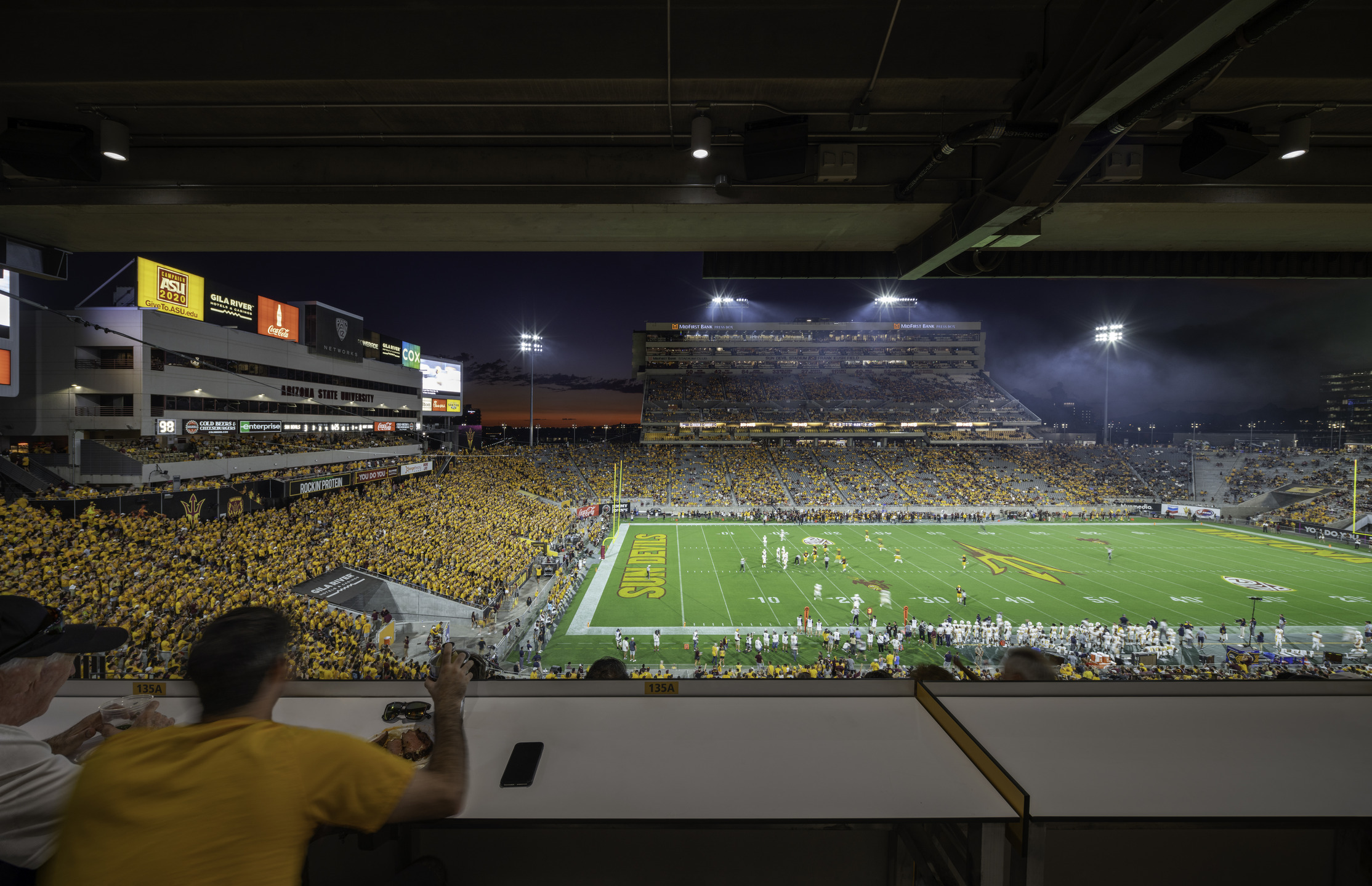 An interior view of the dining hall. A buffet and cooler have wood accents and are surrounded by menu screens.