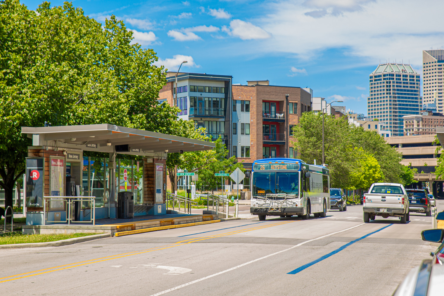 A bus drives past a mixed-use residential building.
