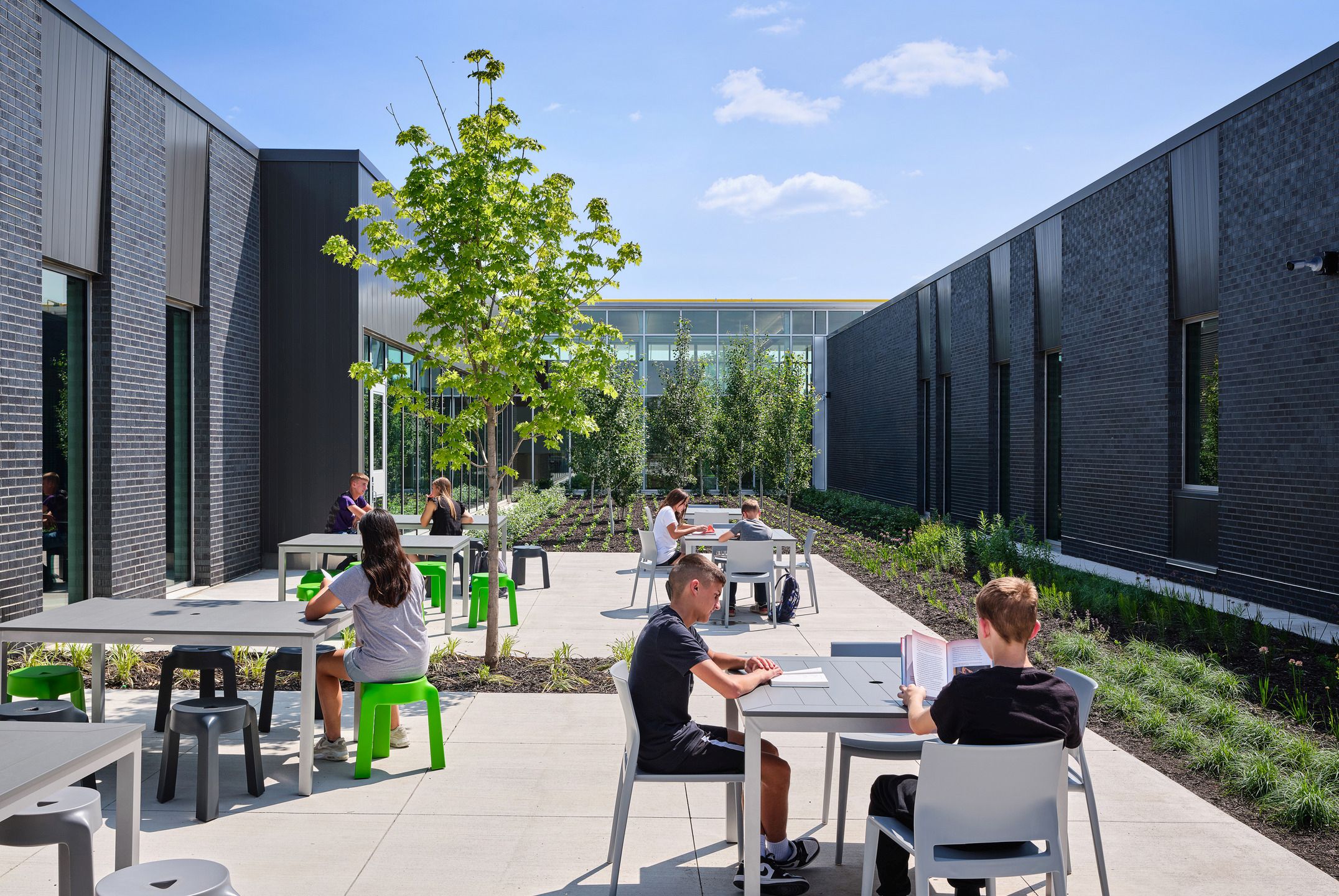 Students sit and study in an outdoor courtyard. 