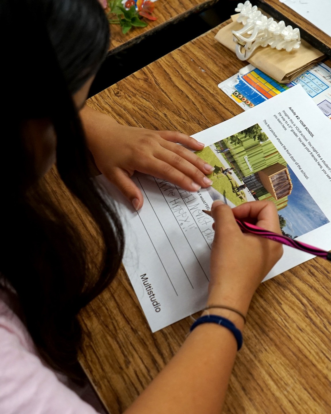 A student responds to a worksheet prompt asking their feelings about a render showing a new school building.