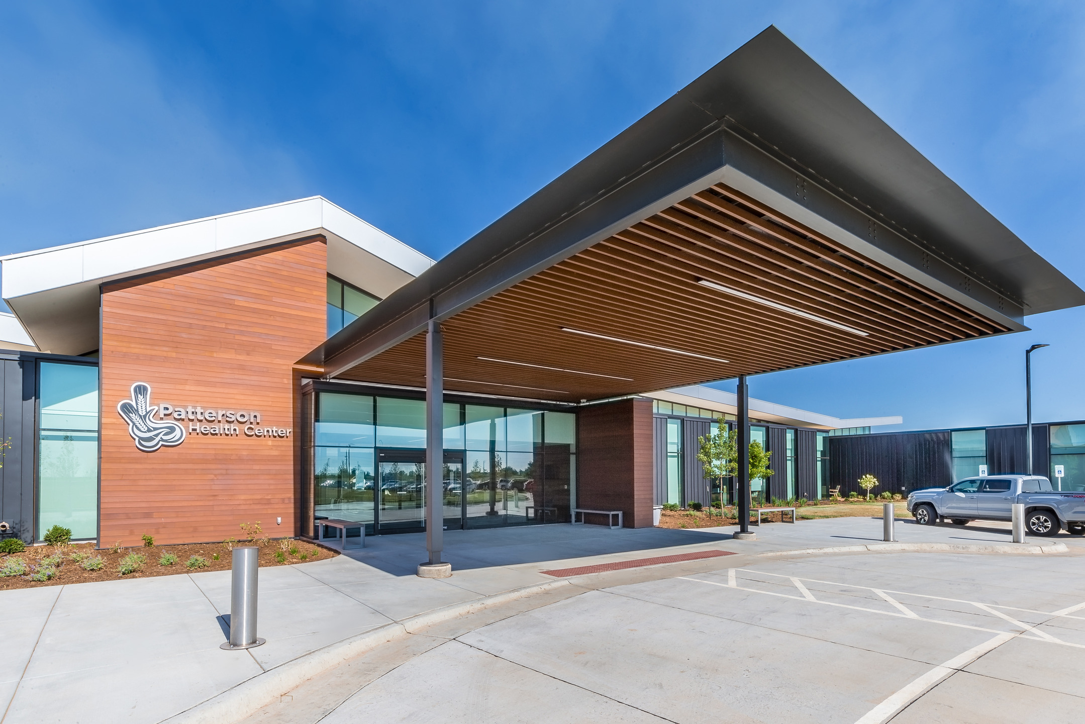 A large awning with wood slatting underneath shades the hospital entrance.