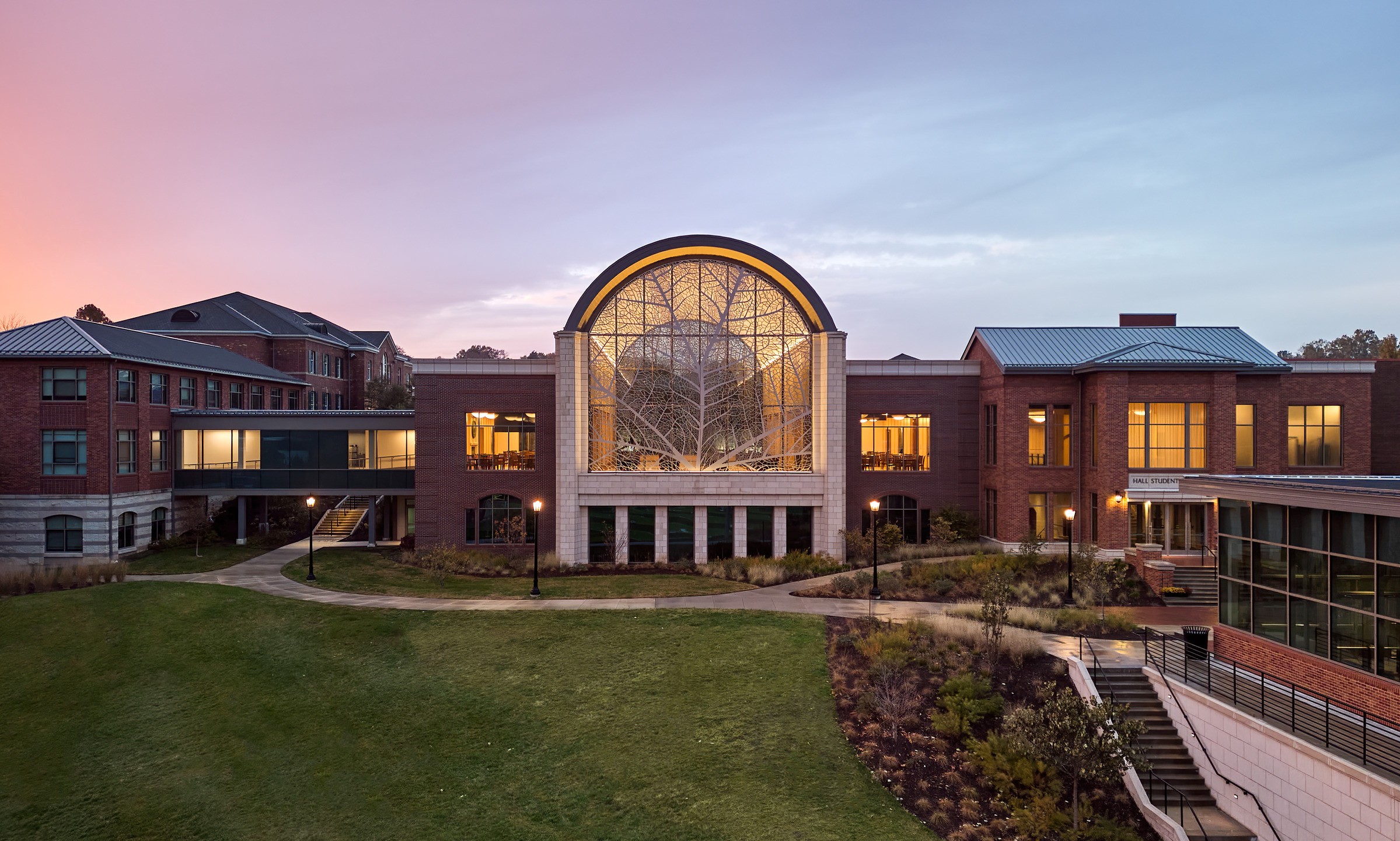 Dusk photo of Hall Student Center, Patterson Hall, a skywalk, and Centennial Hall which enclose the fourth side of the campus quadrangle.