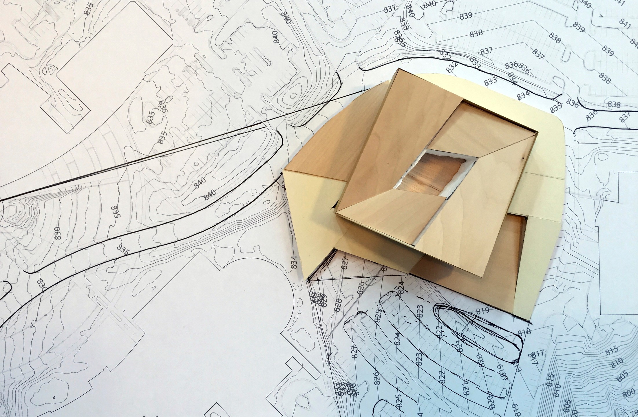 Image of a massing model of the building sitting on a printed site plan.