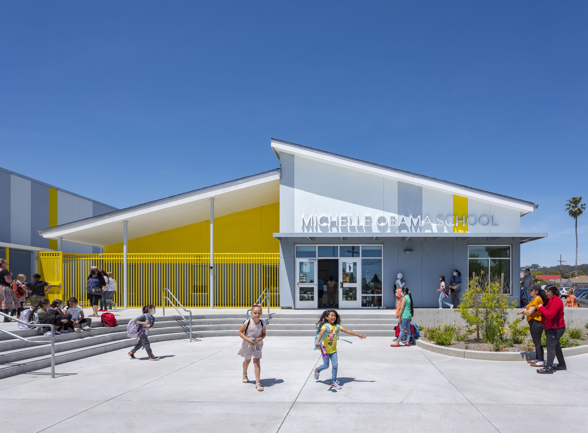 Front entry of Michelle Obama School with elementary students and parents/guardians.
