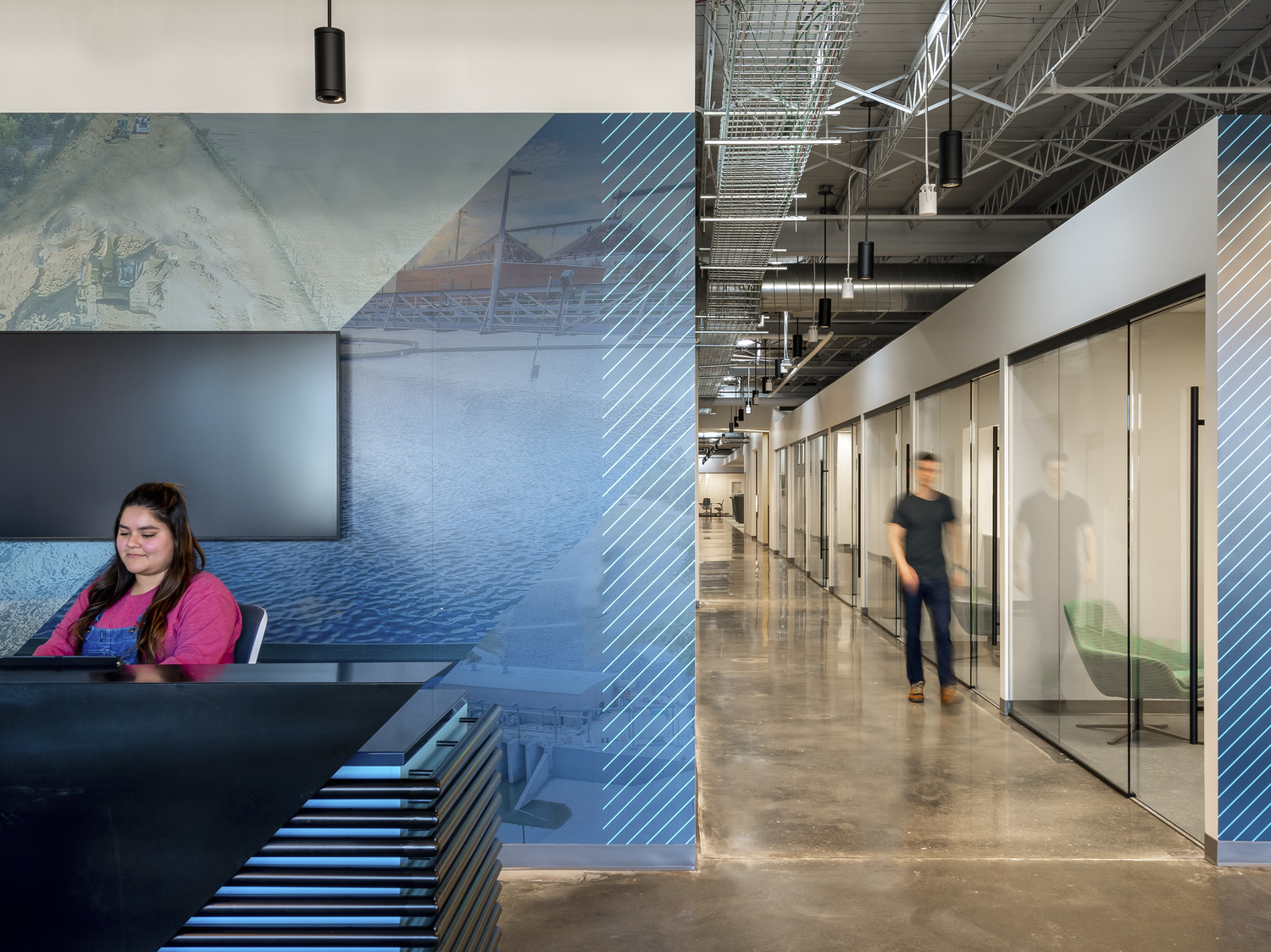 Reception area and hallway with adjoining, glass-lined conference rooms.