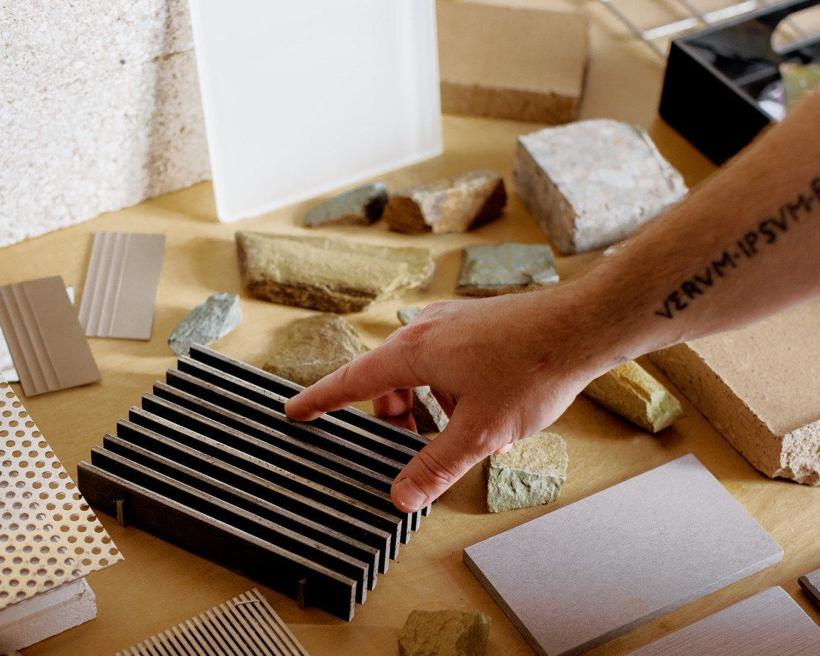 Joey Gamblin reaches for materials laid out on a table.
