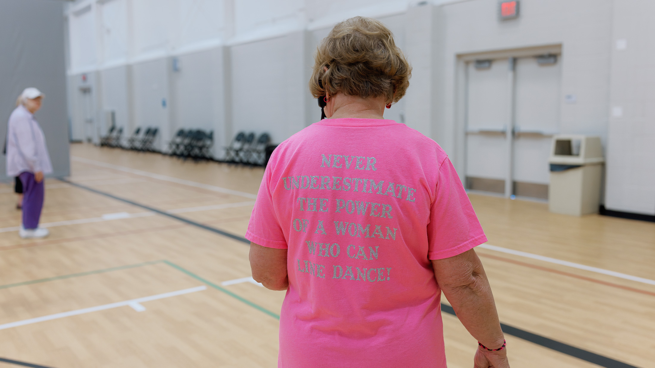 The back of a shirt on a line dance instructor at the Lenexa Old Town Activity Center reads, "Never underestimate the power of a woman who can line dance!"