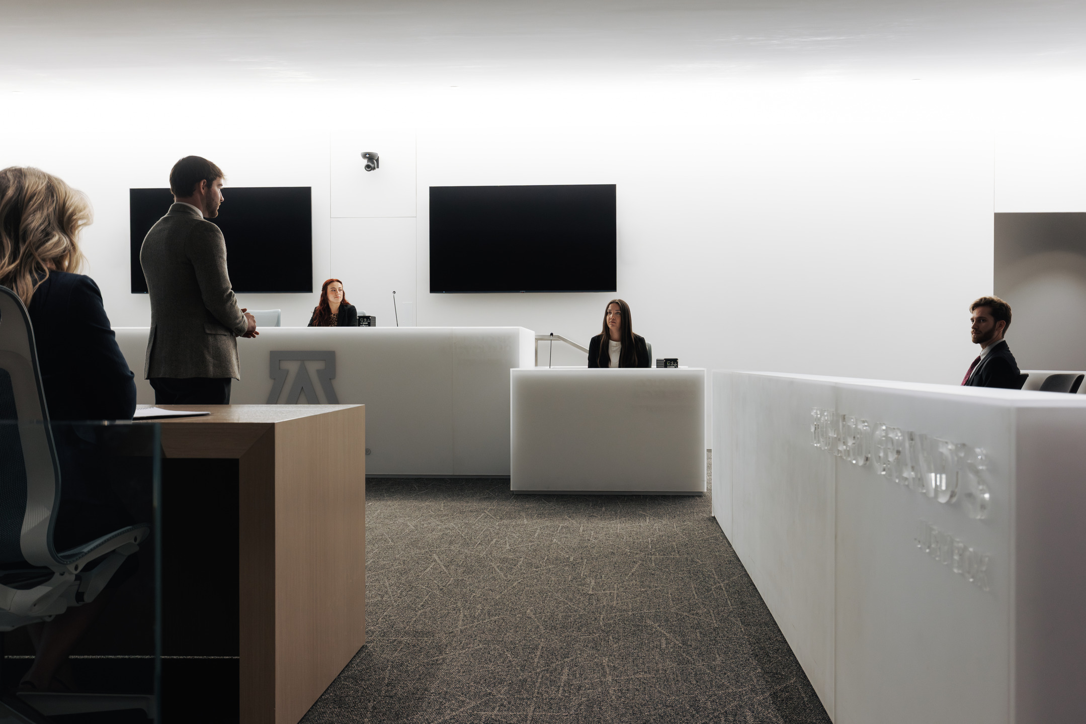 Students sit and stand in a mock courtroom, practicing litigation at the University of Arizona College of Law.