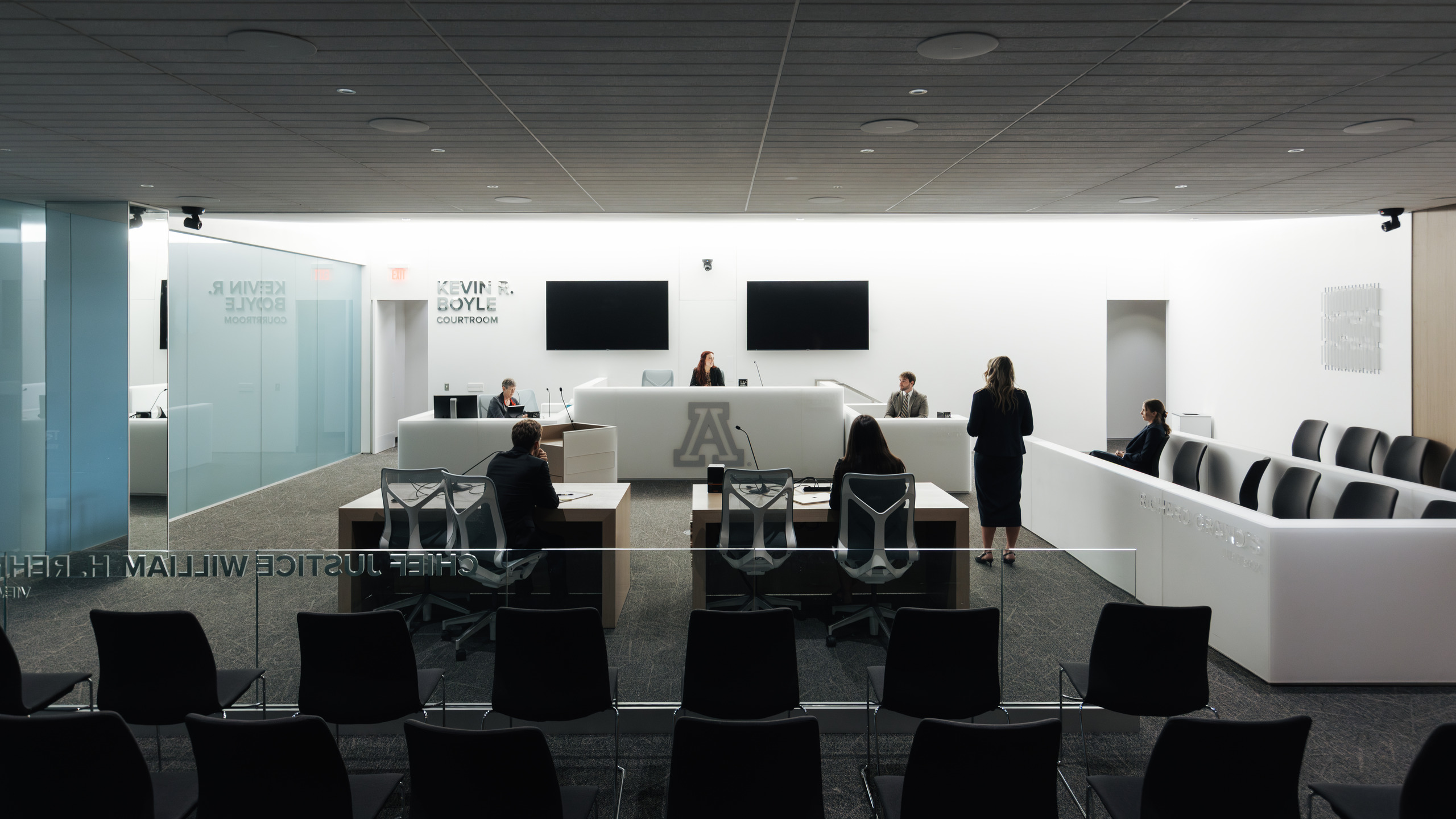 Students sit and stand in a mock courtroom, practicing litigation at the University of Arizona College of Law.