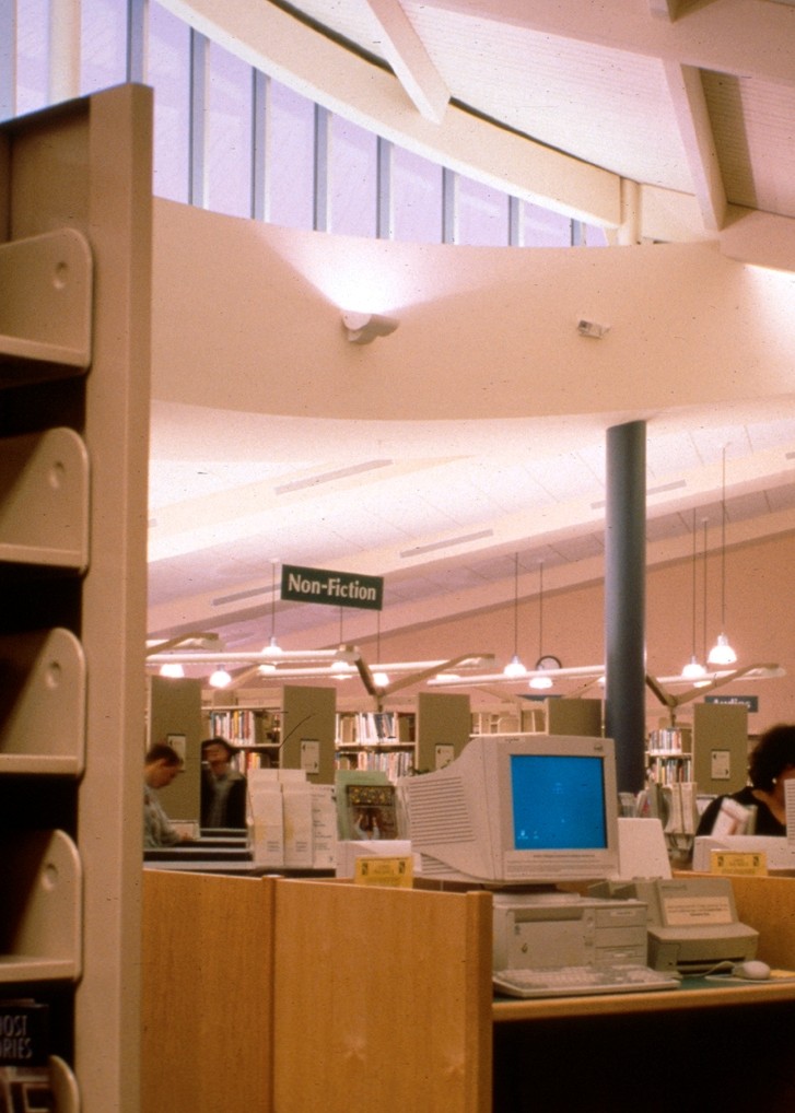 An archival photograph shows the interior of the original library building in the 1990s.