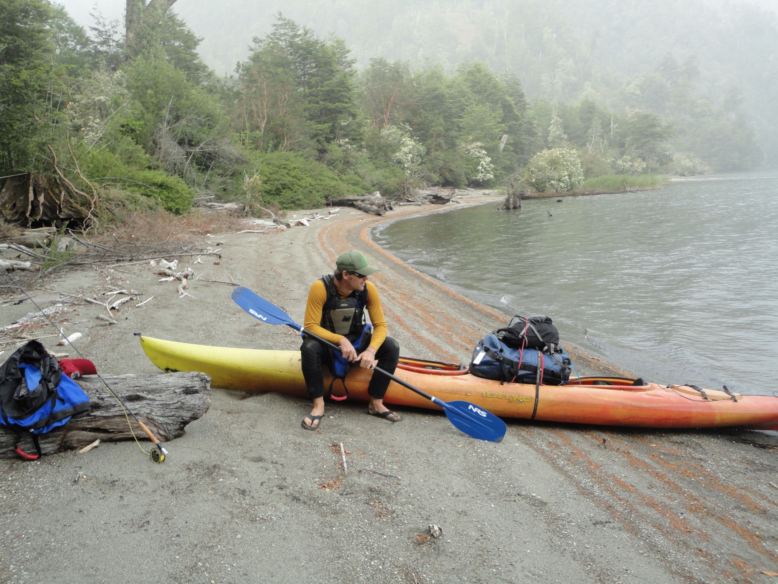 Ian Colburn sits in a kayak at a lake's edge. 