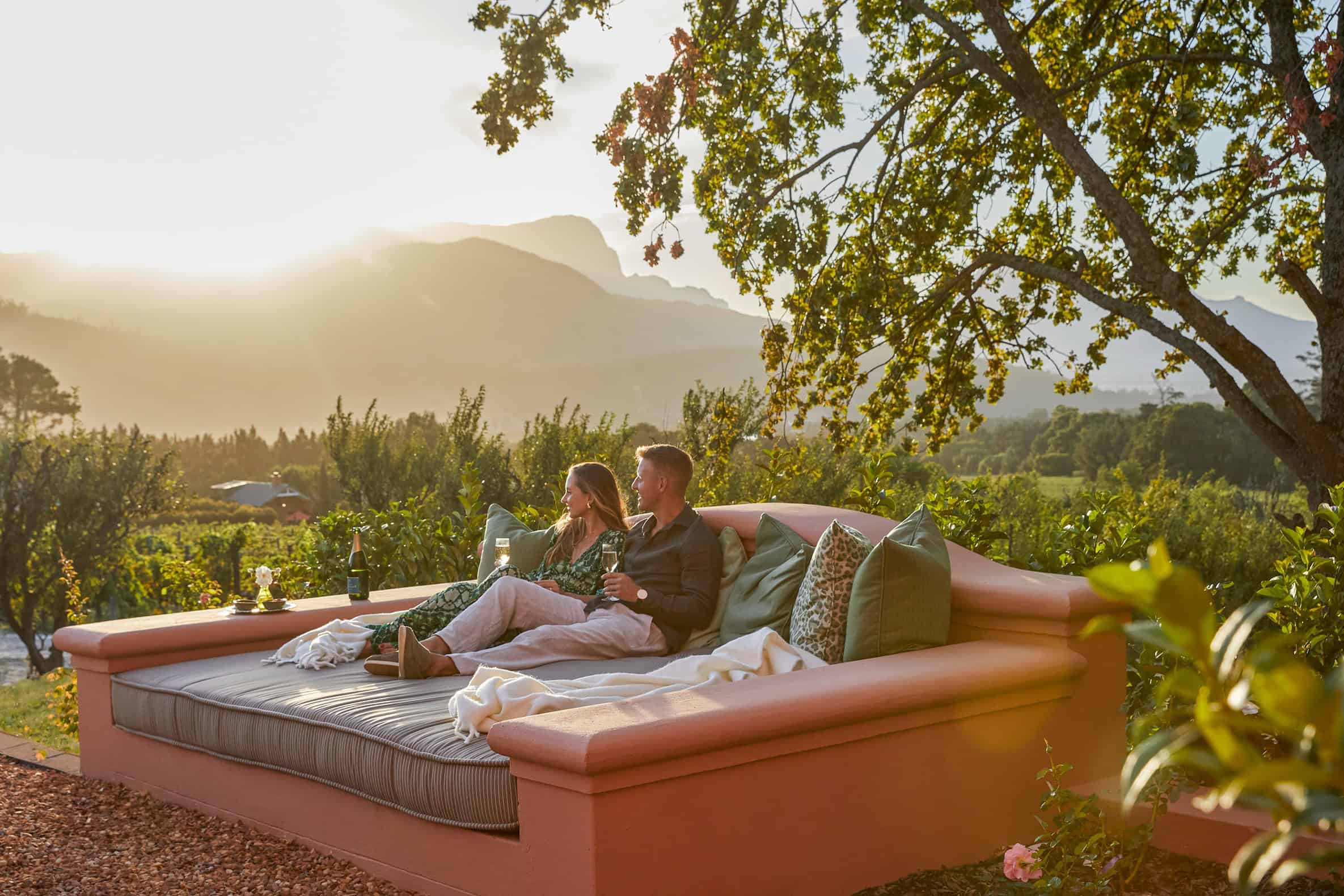 A couple lounging outdoors at La Residence in Franschoek, South Africa
