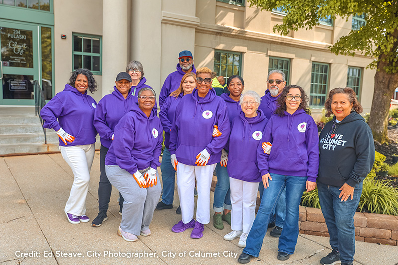 Members of the Building the Ark residential committee pose for a group photos with information boards illustrating results of the neighborhood survey