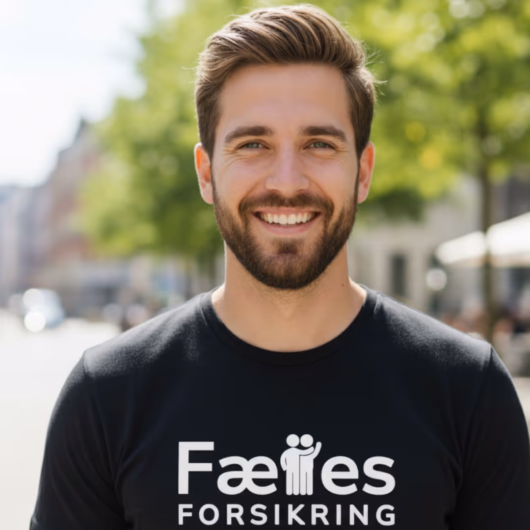 Glad mand i en Fælles Forsikring T-shirt. Represænterer en medarbejder mh.t. arbejdsskadeforsikring