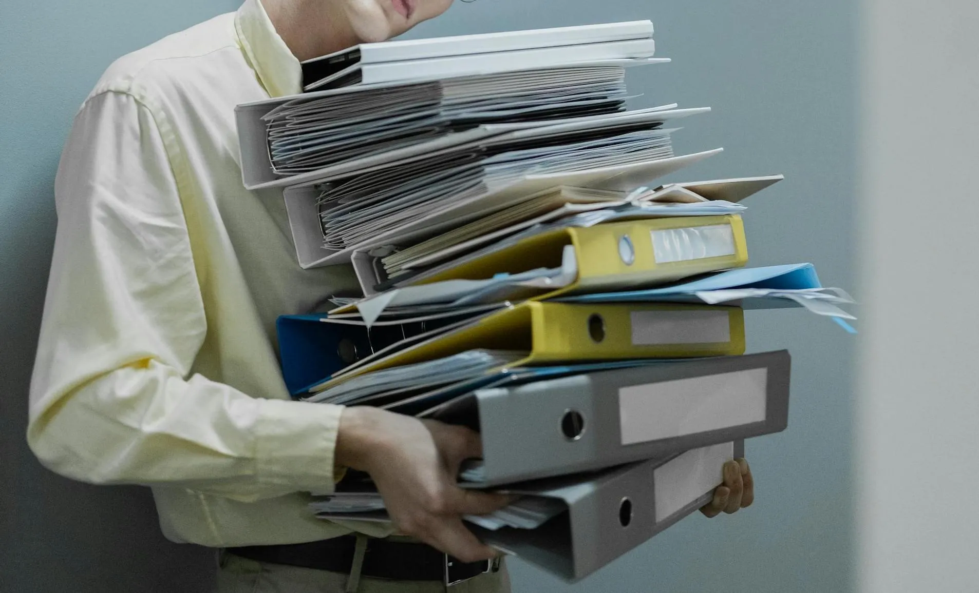 A man holds a large stack of filers.