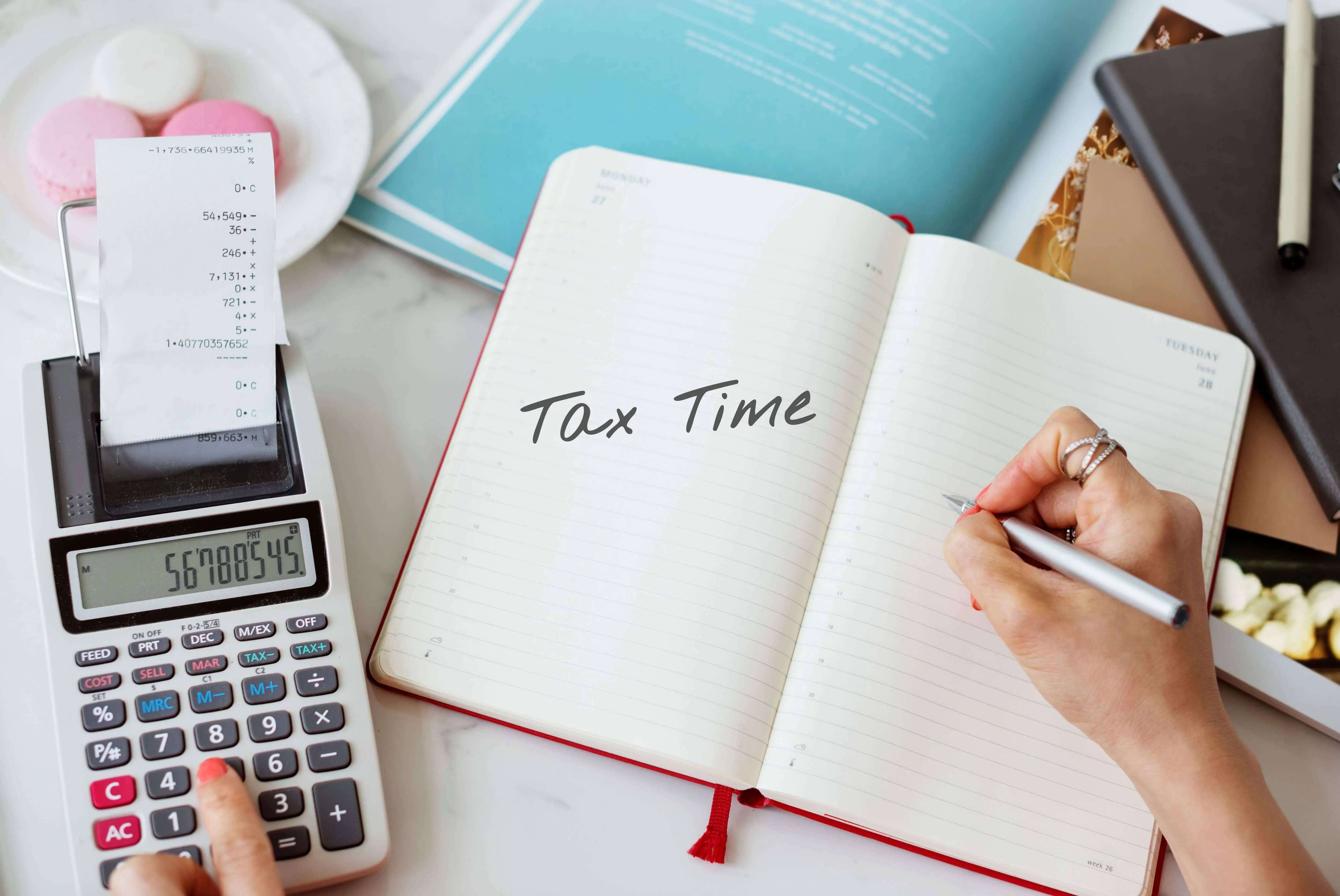 Close up of woman's hand writing in a tax time notebook, calculating sales tax by state