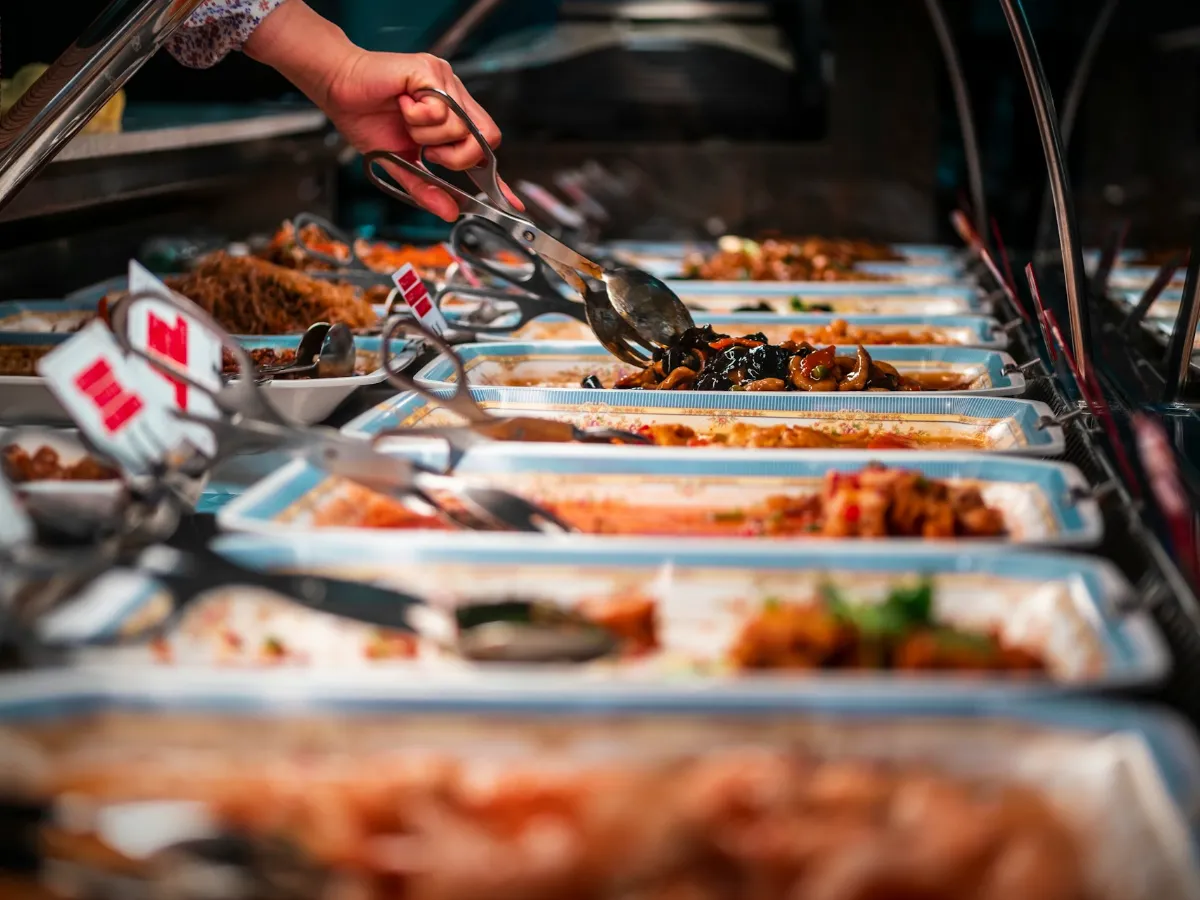 Customer selecting food items out of a hot food station