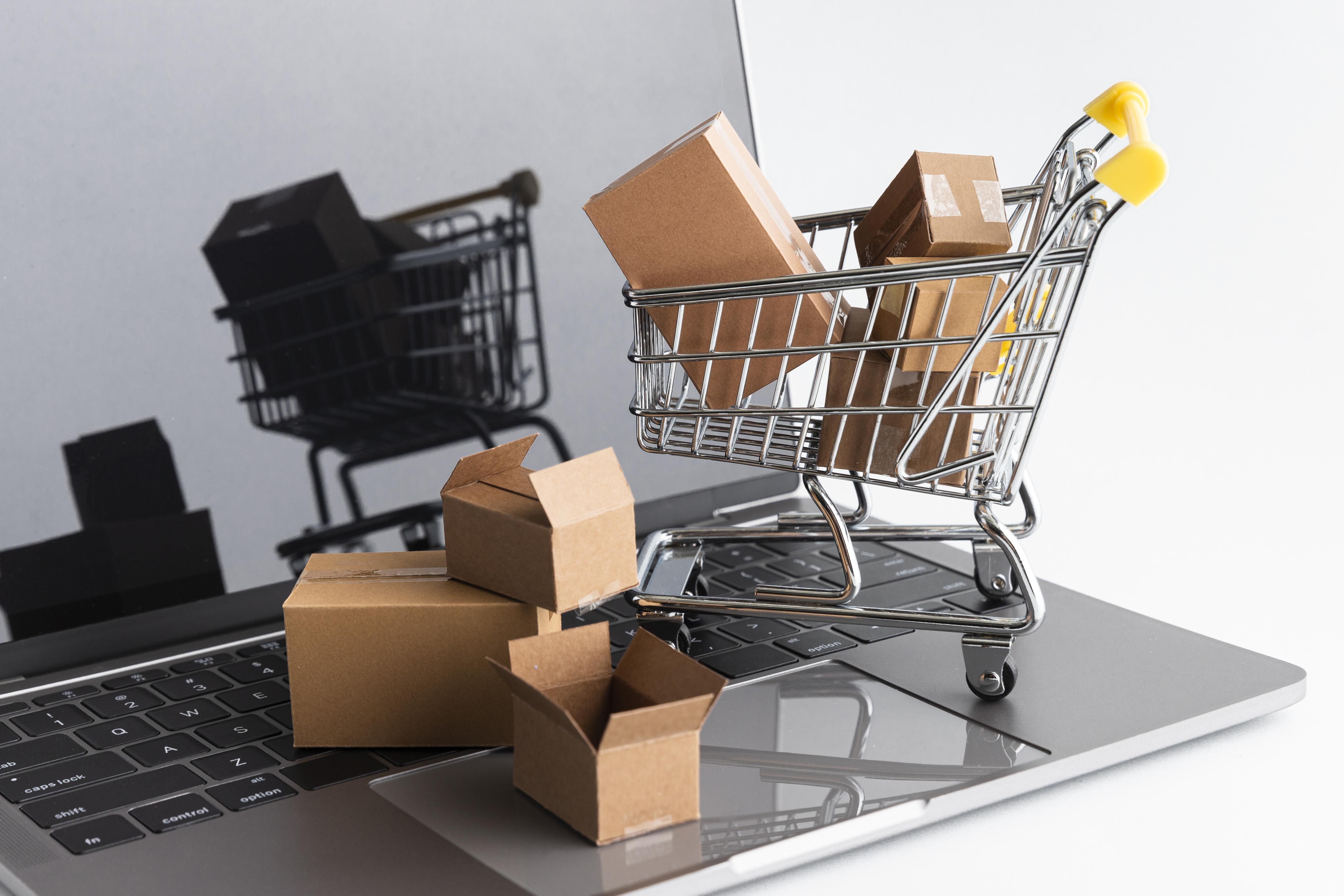 Miniature trolleys and boxes sitting on a laptop, depicting is Shopify a marketplace facilitator