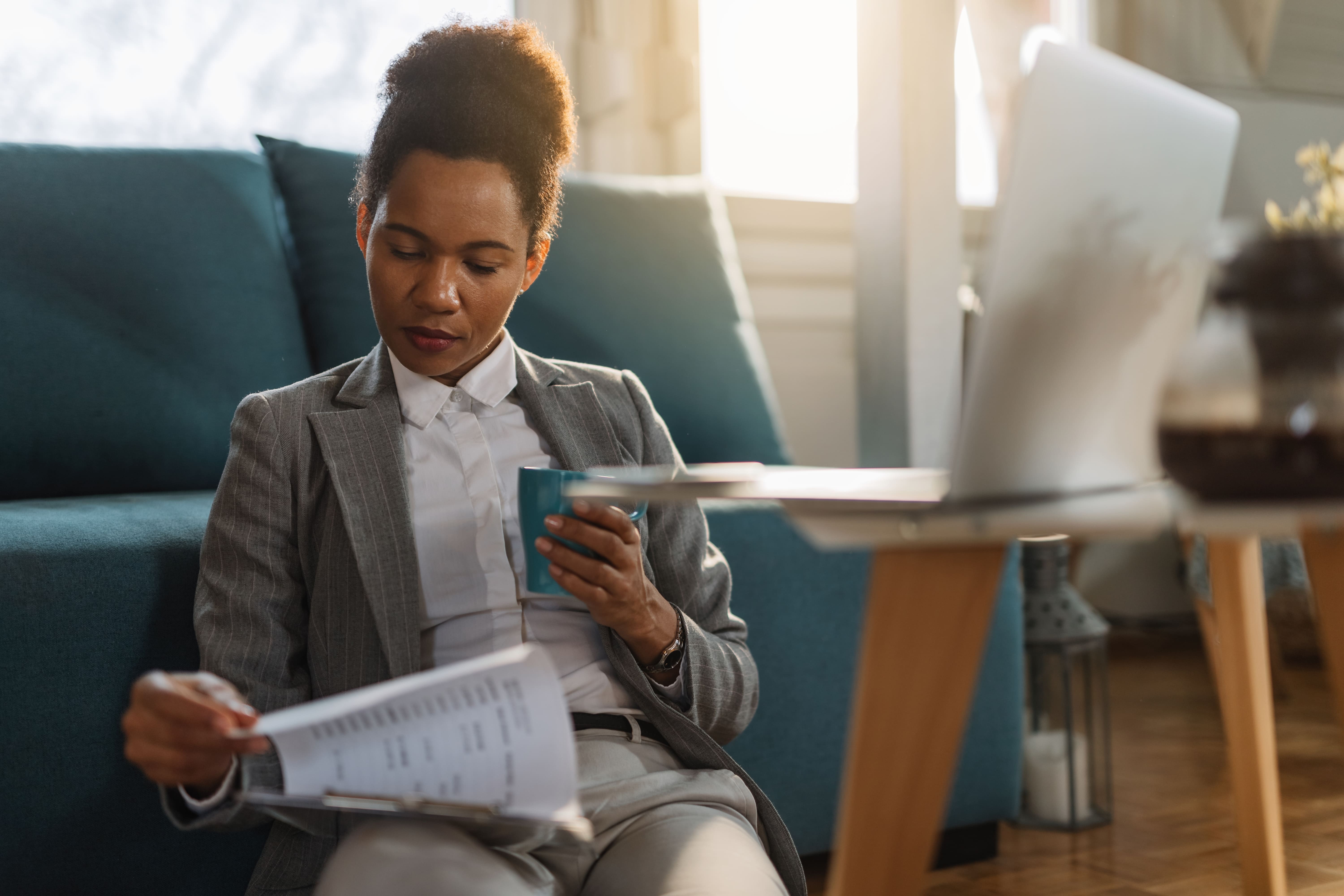 Young female professional in formal attire reviewing documents for multi-state sales tax filing
