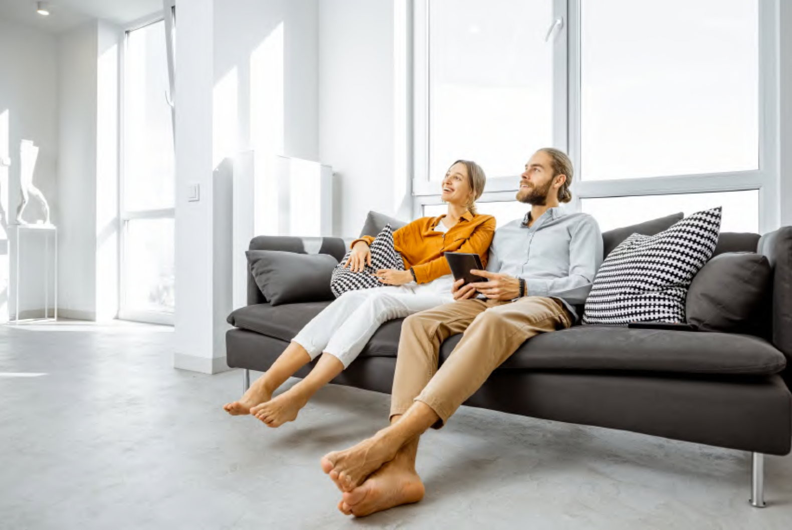 couple sitting on a couch in their clean home.