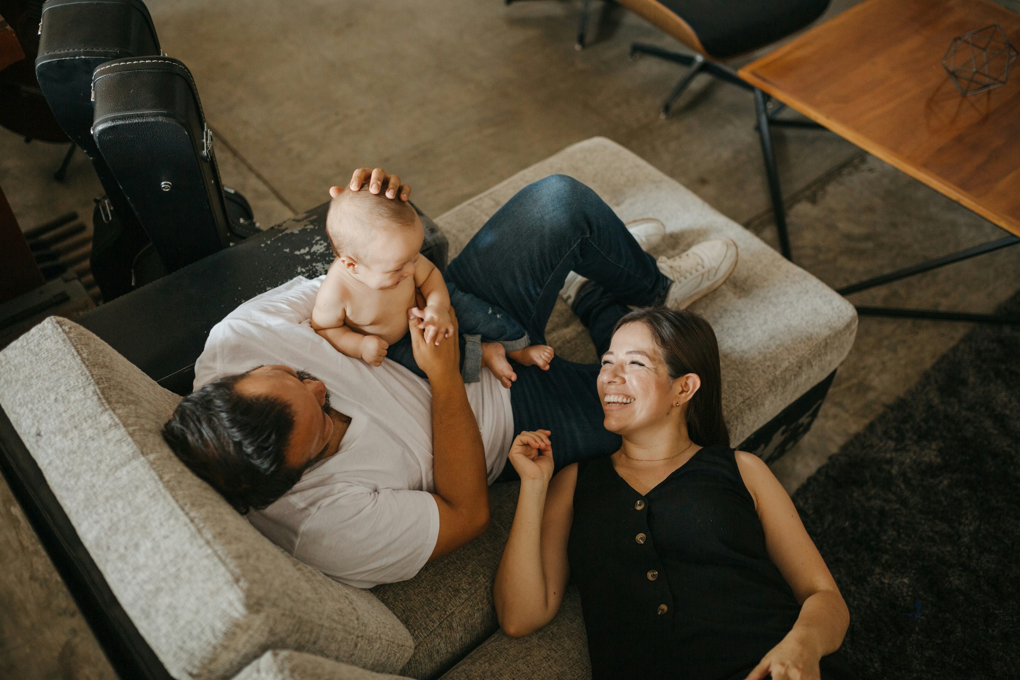 parents laughing and playing with their baby