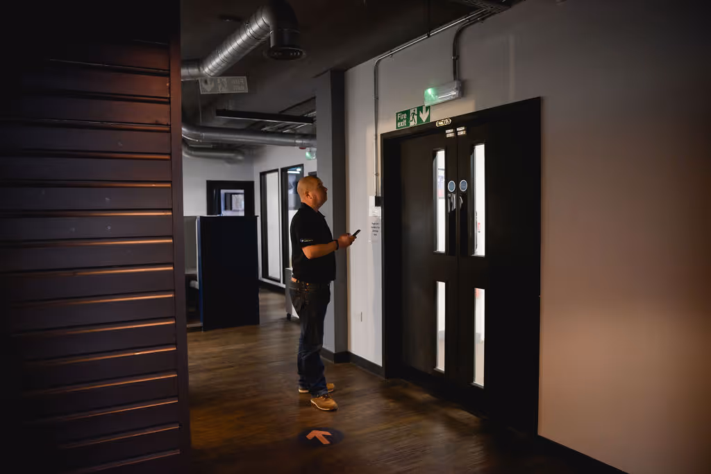 A man inspecting a set of double fire doors.
