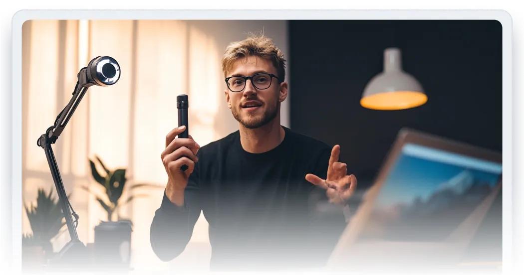 A man holding a cell phone in front of a microphone.