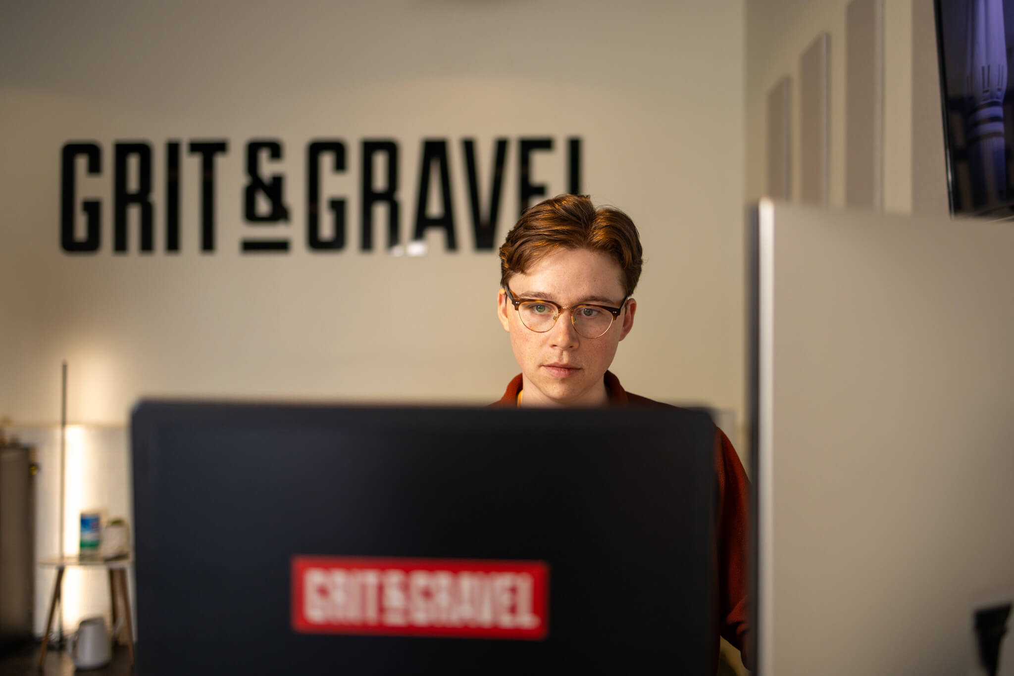Person using a graphic tablet and keyboard with color swatches and a coffee cup on a desk.