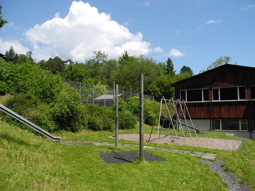 Ein Aussenspielplatz mit Rutsche, Schaukel und Reckstange