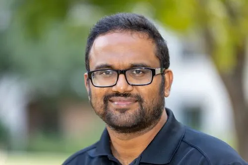 A man wearing glasses and a black shirt.