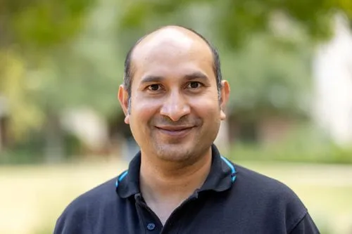 A man wearing a black shirt and blue collar.