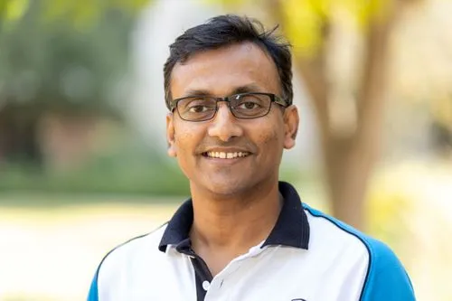 A man wearing glasses and a blue shirt.