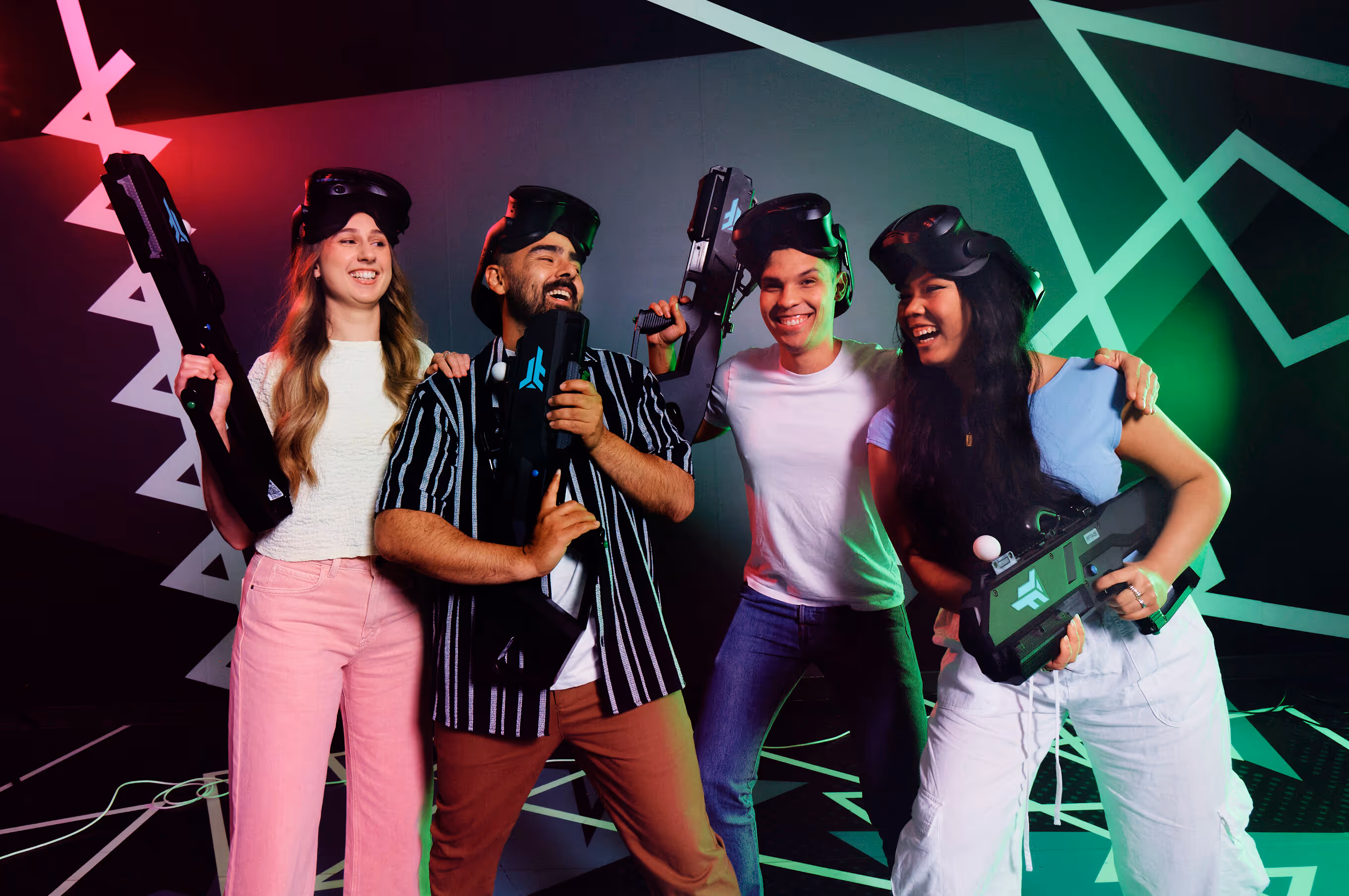 Vier lachende Personen mit Virtual-Reality-Brillen und Laserpistolen im 7th Space spielen Free Walk Pro.