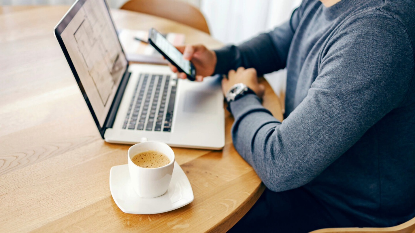 Selective focus on morning coffee on the table with businessman in the background.
