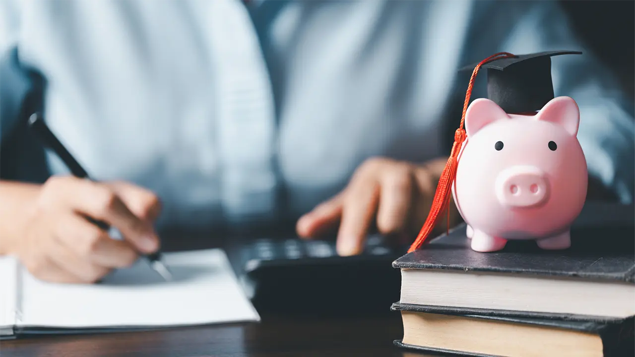 A student reviewing financial documents on a laptop, representing student loan fraud and identity theft risks for borrowers.