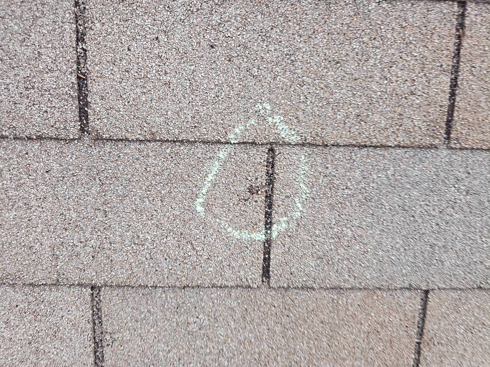 Minnetonka roof leak inspection, chalk-circled puncture at a shingle seam.