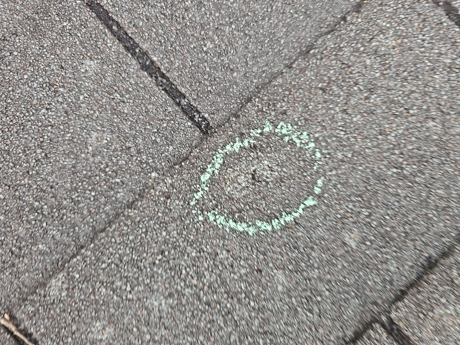 Minnetonka roof inspection, circled puncture on charcoal shingles.