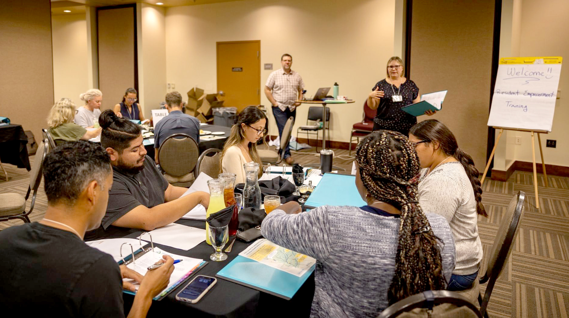 Person speaking to a group of people at round tables