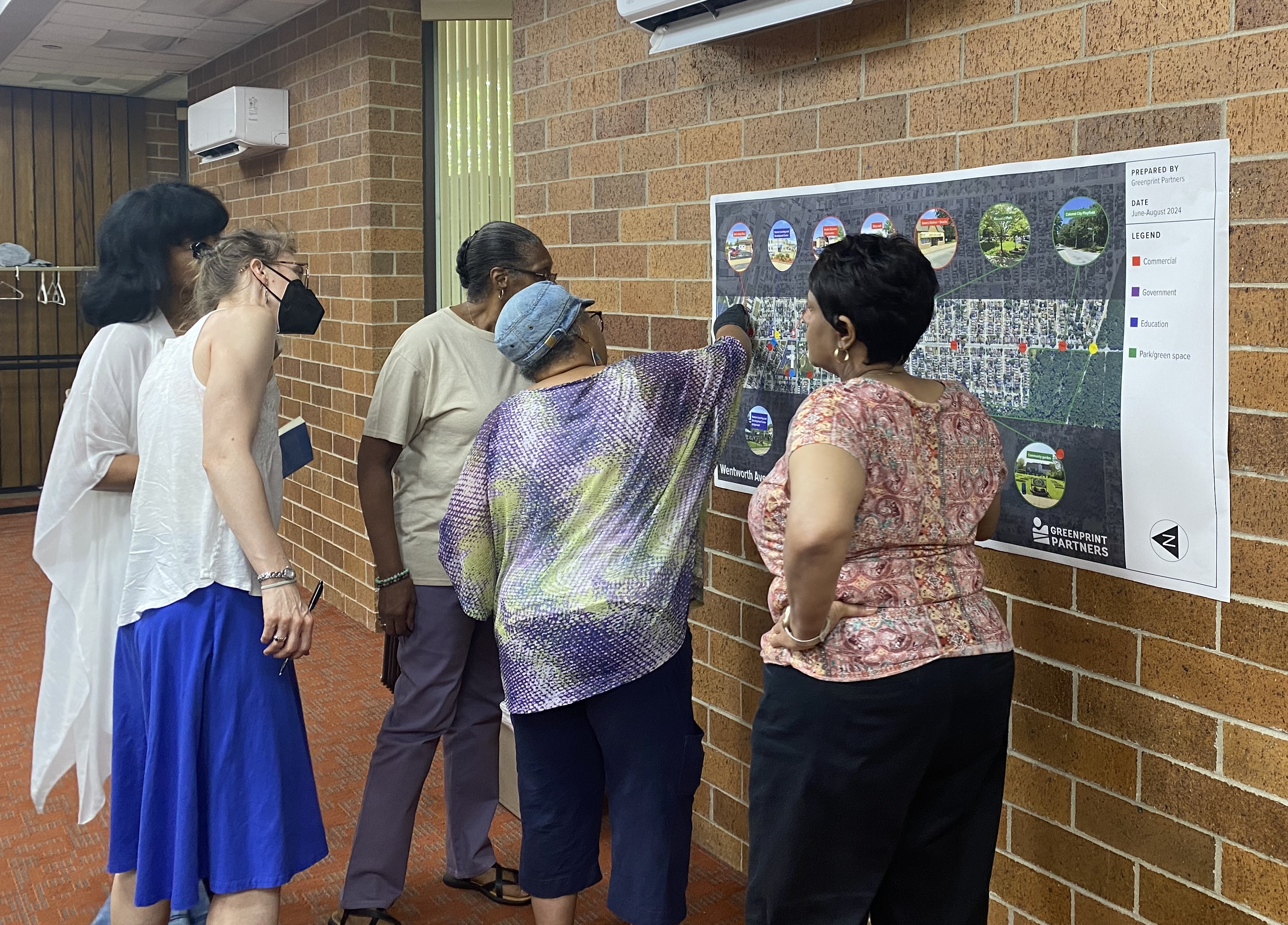 Group of people standing in front of large map on wall