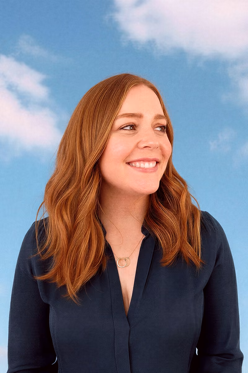 Marissa Johnson smiling in a navy blouse against a blue sky