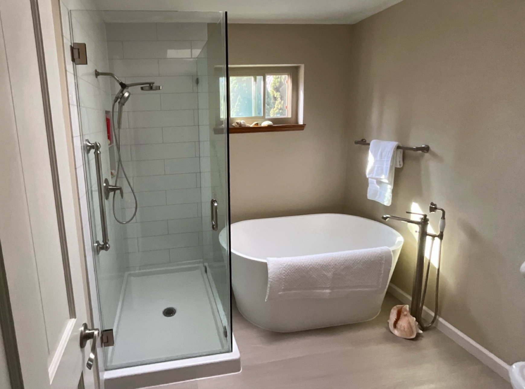 coastal bathroom with a freestanding tub and open walk-in shower 