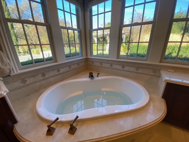 Deep Soaking Tub in a Main bathroom in Southern California with natural lighting from windows