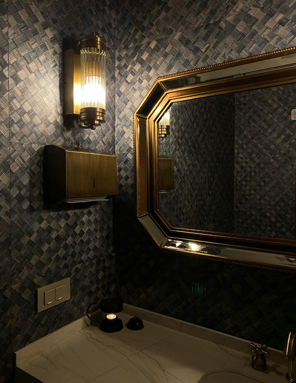 bathroom vanity with dimmed lighting through a wall sconce