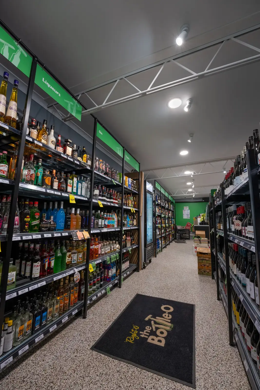 Bottle shop aisles lit by new overhead track lighting, installed by JPG Tech