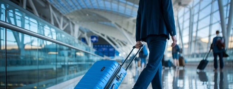 Frequent traveller walking through Dubai airport with luggage before a long flight, highlighting travel fatigue and post-flight recovery.