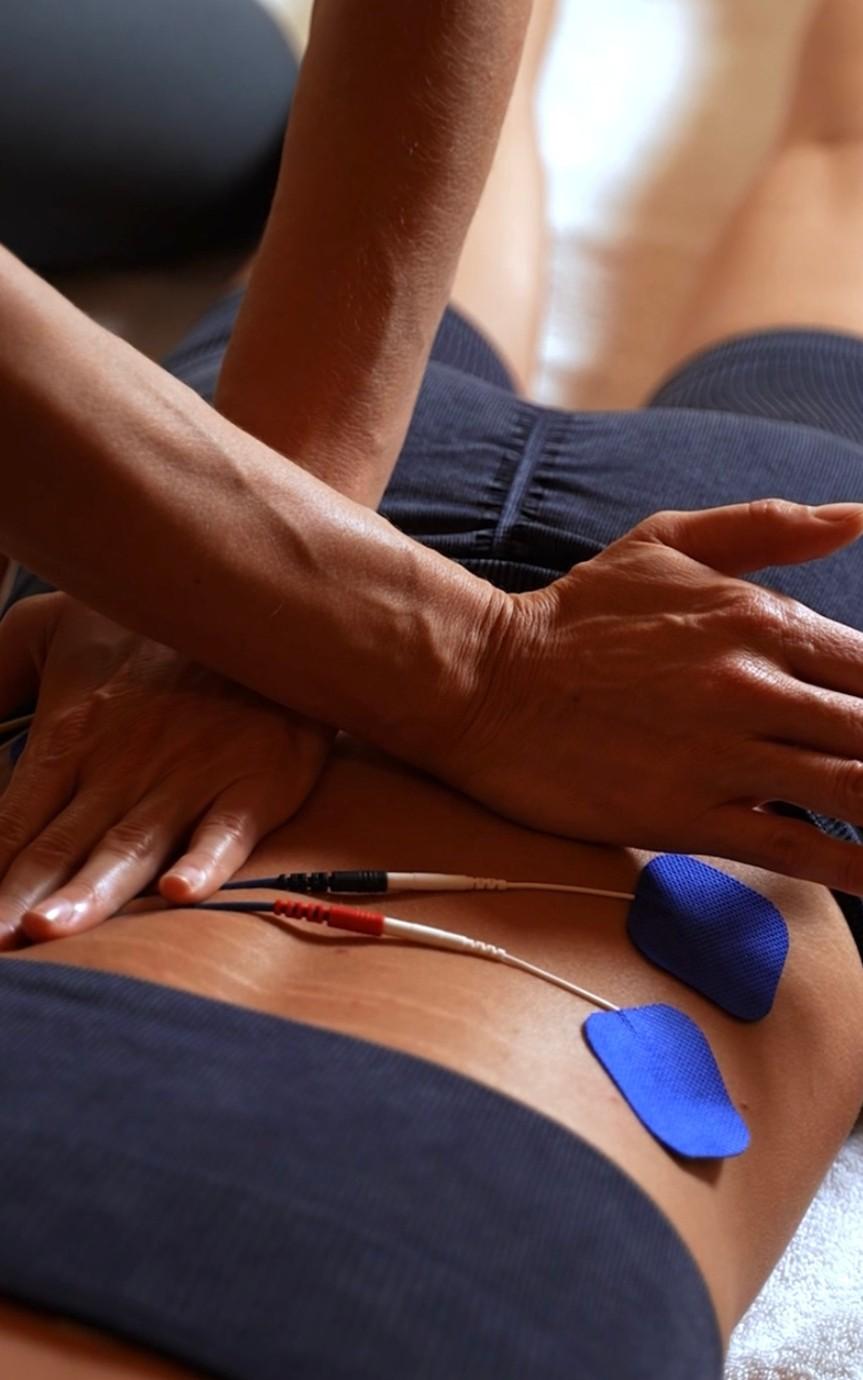 Manual therapist performing hands-on treatment with electrotherapy to support muscle recovery, pain relief, and improved movement at Wellnest Dubai.